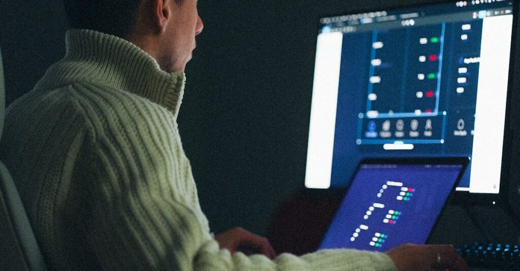 Adult male working on a computer at night in a dark room.