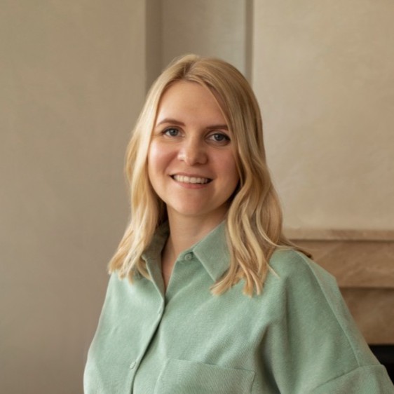 Anna Zmiievska - Fresh Thinking Labs Smiling blonde woman in a mint green button-up shirt indoors, facing the camera.